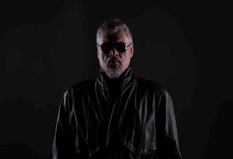 "Mr Smoe" in a leather jacket and dark glasses—a strange presence tied to An Old Man’s Insight into the Candle Face Mystery, part of Candle Face Chronicles, published by Branching Plot Books.