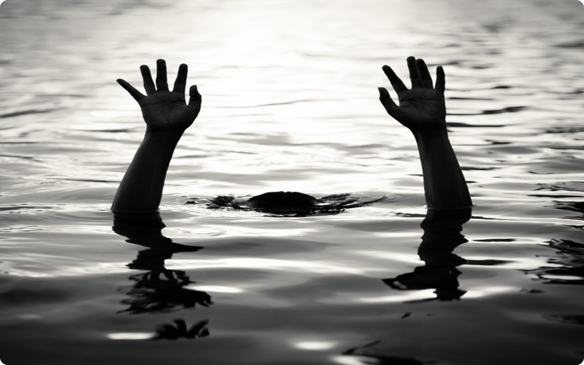 Black and white image of Isabel, the forgotten daughter of La Llorona, drowning with her hands reaching above the water as she sinks below the surface.
