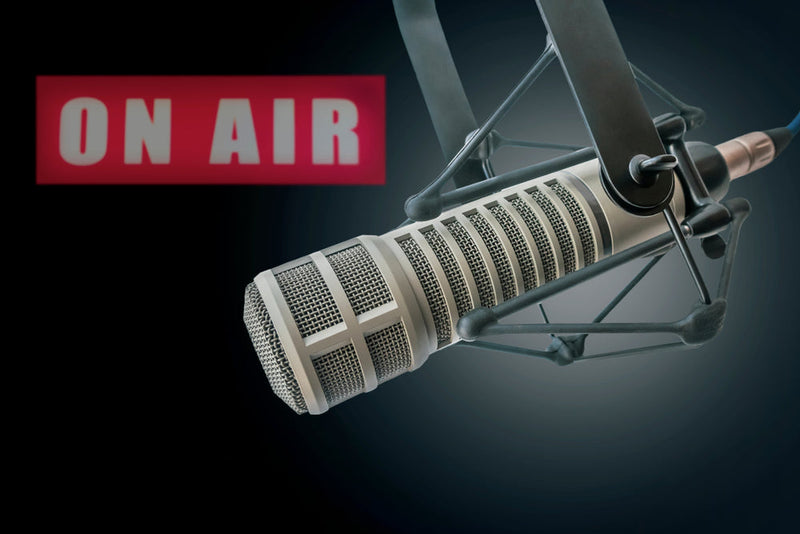 A professional microphone in a recording setup with an illuminated 'ON AIR' sign in the background, teasing the upcoming launch of the Candle Face Chronicles Podcast.