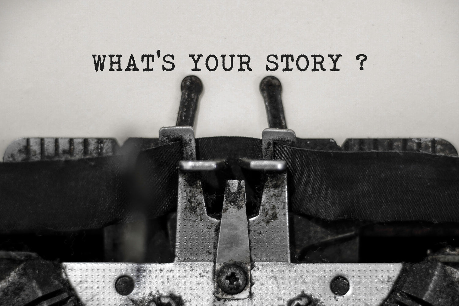 Close-up of a vintage typewriter with the words "What's your story?" typed on paper.