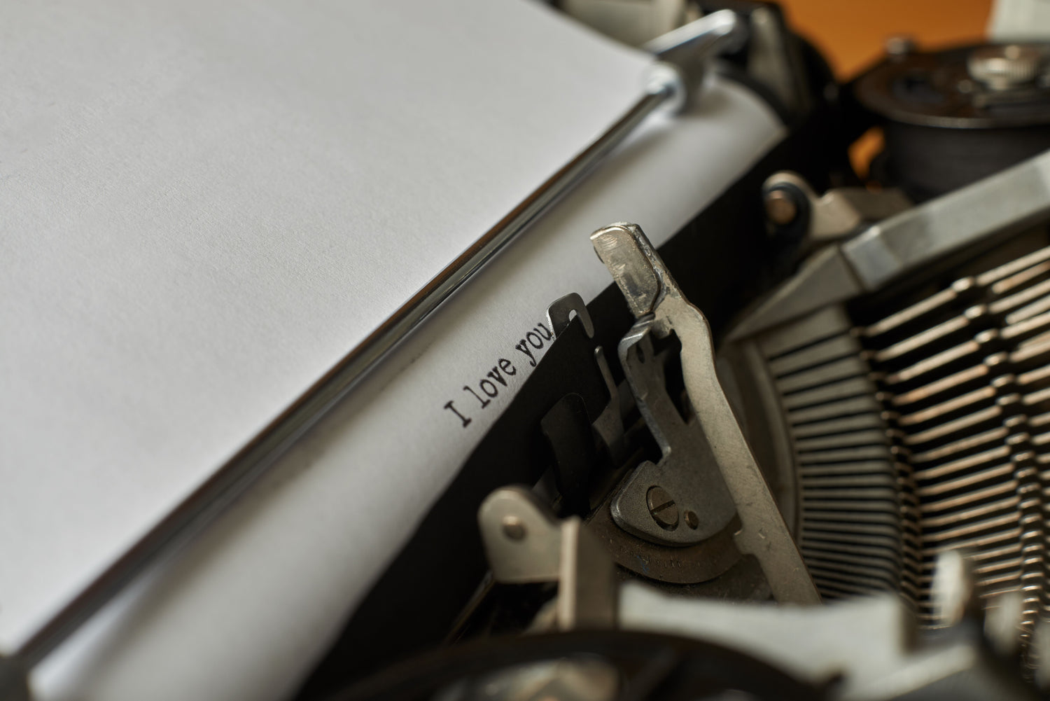 Close-up of a typewriter carriage with "I love you" typed at the bottom of the page.