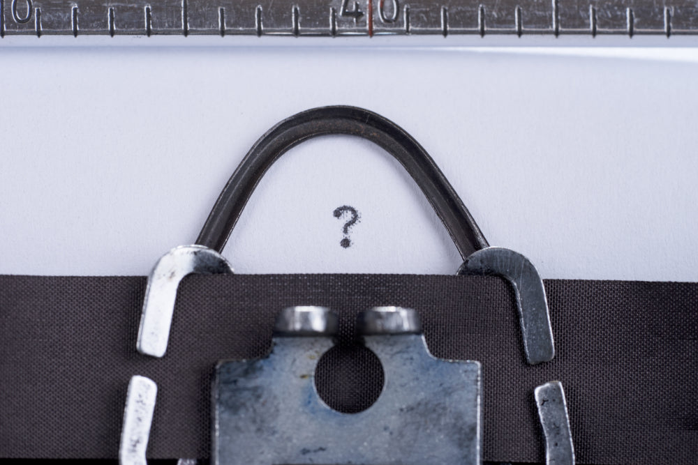 Close-up of a black belt with a metal buckle on a white background